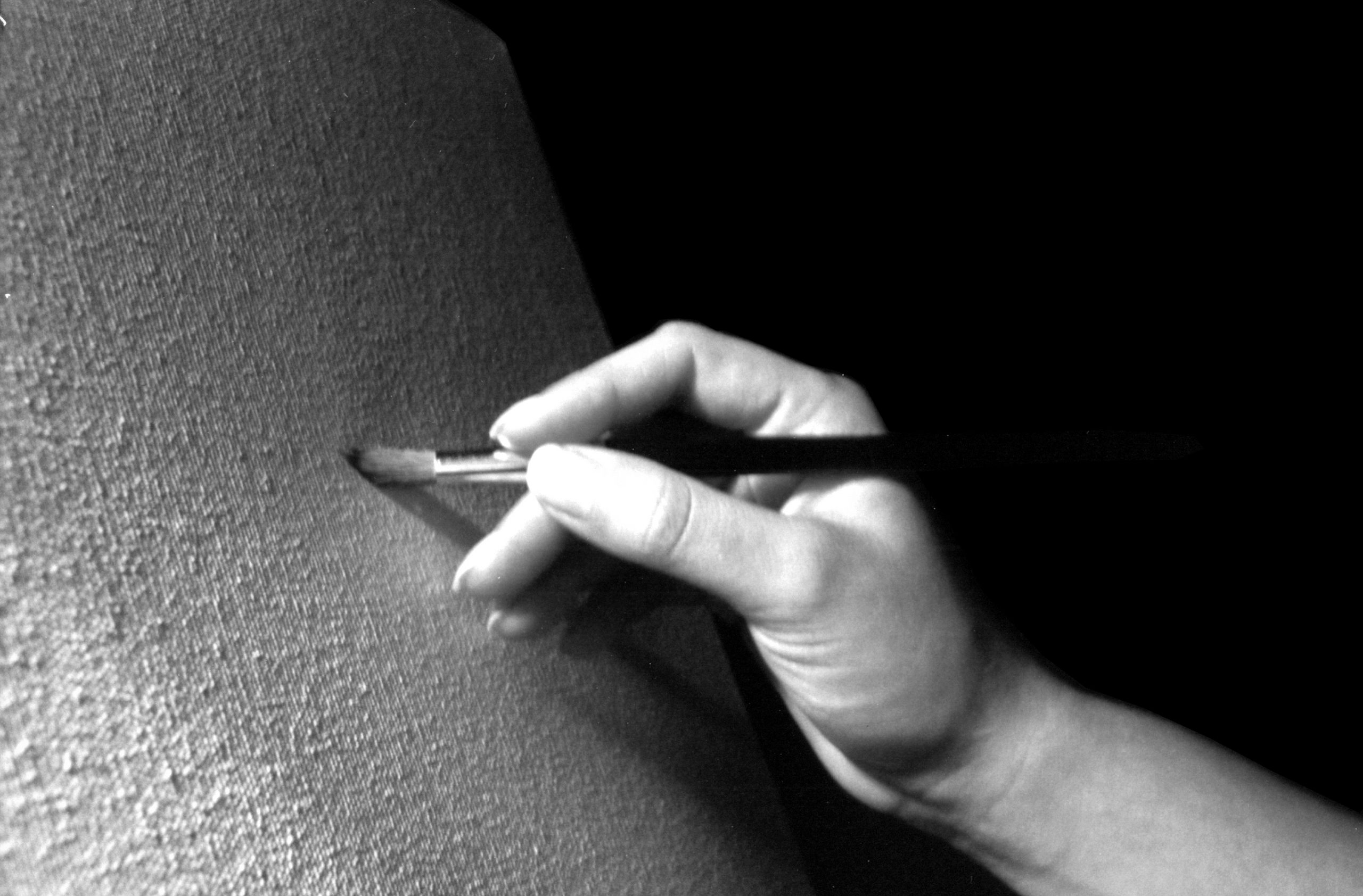 Artist's Hand Painting a Blank Canvas