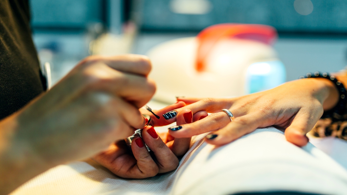 Persona haciendo un manicure en uñas coras (Foto vía Getty images)
