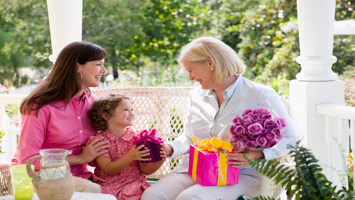 Madre e hija entregando un regalo de Día de la Madre a la abuela (Foto vía Getty Images)