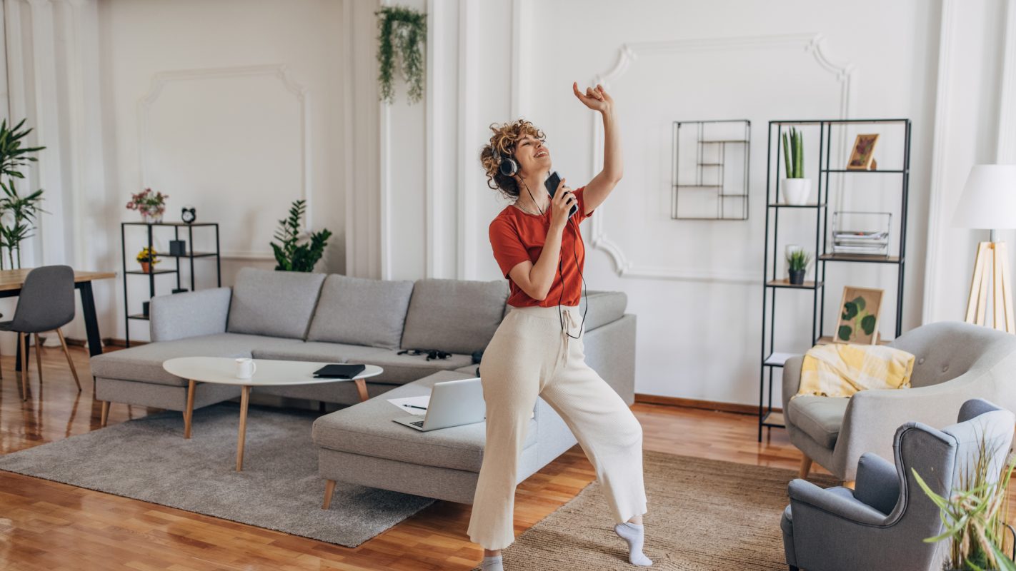 Mujer cantando y bailando alegremente (Foto vía Getty Images)