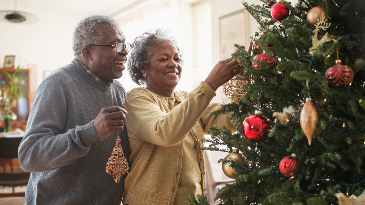 Pareja decorando el árbol de Navidad.