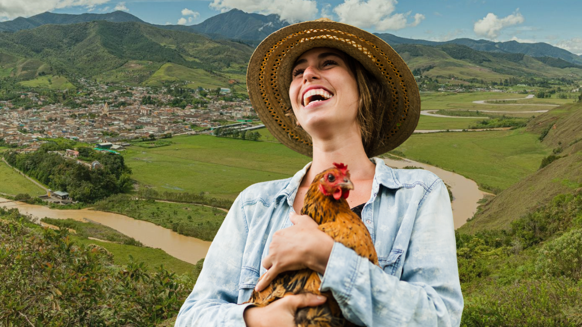 Persona con sonriendo con una gallina y de fondo aparece Urrao. Crédito: Antioquia es mágica/ Getty images.