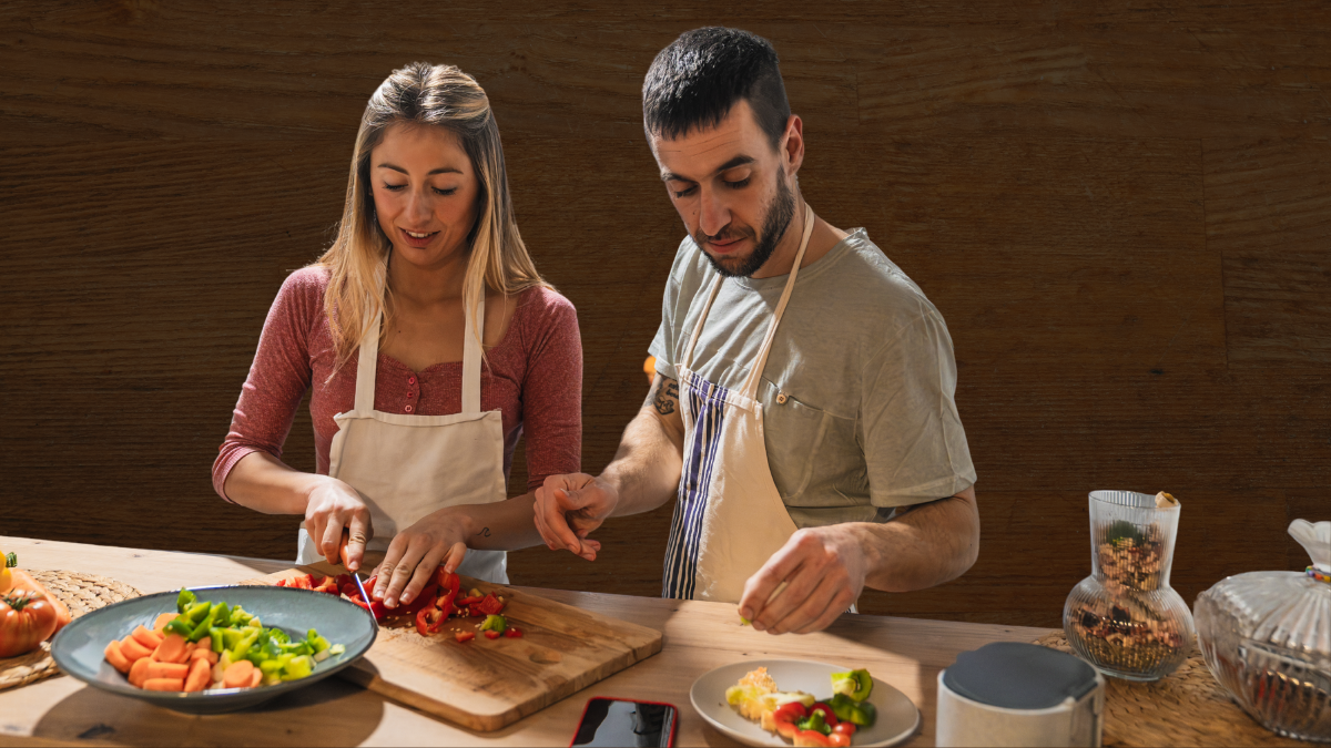 Personas cocinando y usando una tabla de madera. Crédito: Getty images.