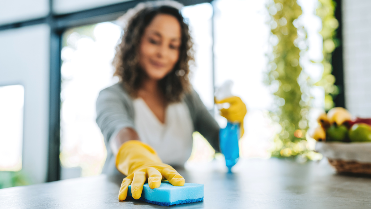 Mujer limpiando una superficie (Créditos: GettyImages).