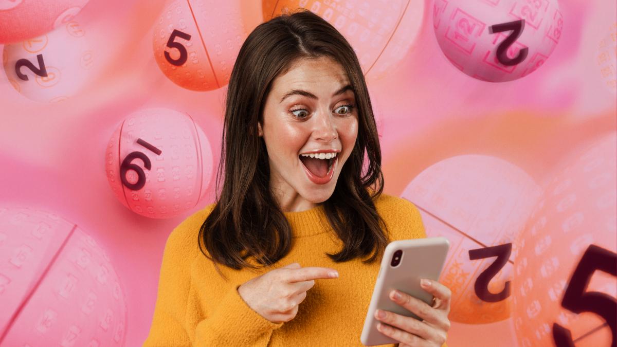Mujer emocionada viendo la pantalla de su celular. | Crédito: Getty images.
