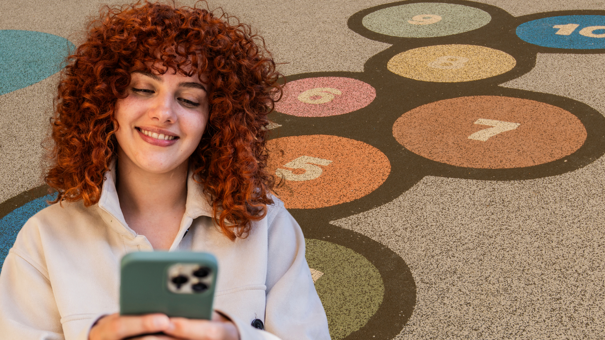 Mujer feliz viendo su celular. Crédito: Getty images.