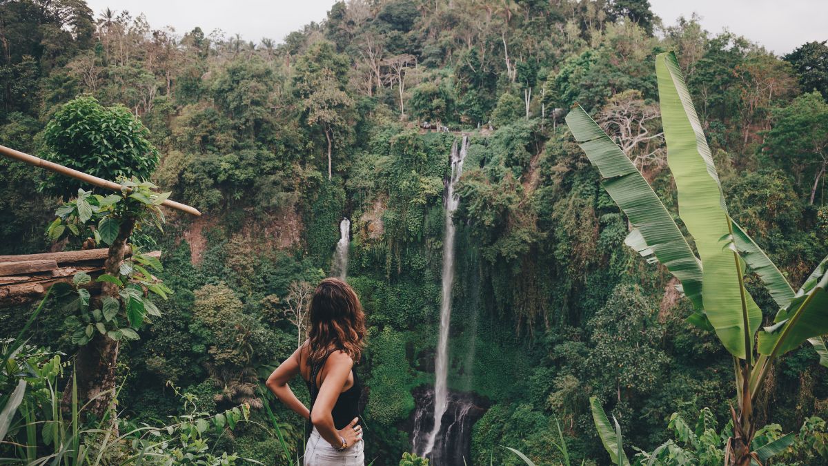 Una mujer en una cascada. | Crédito: Getty images.