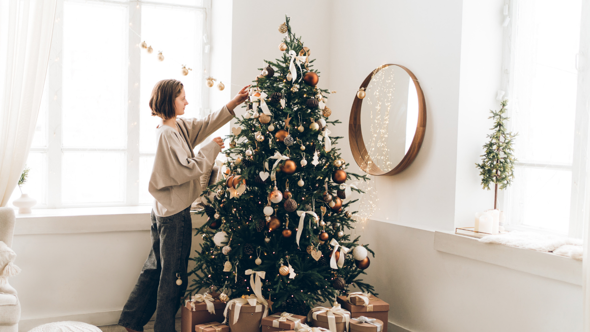 Mujer decorando el árbol. | Crédito: Getty images.