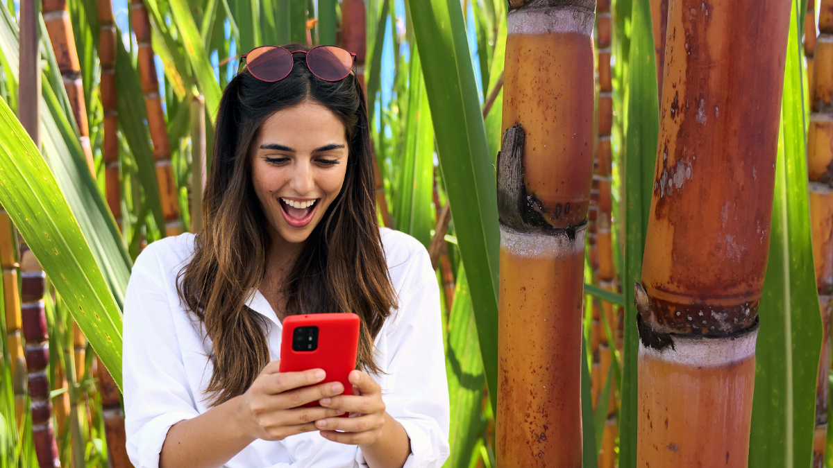 Mujer emocionada viendo su celular. | Crédito: Getty images.