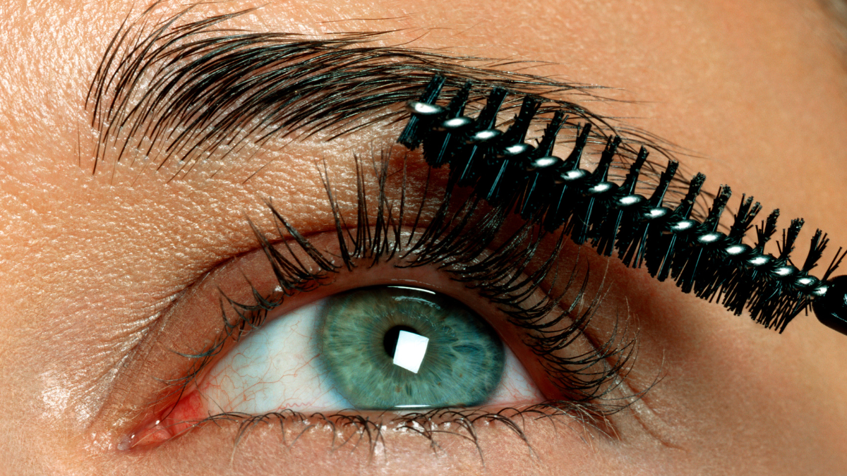 Mujer aplicándose maquillaje en las pestañas, | Crédito: Getty images.