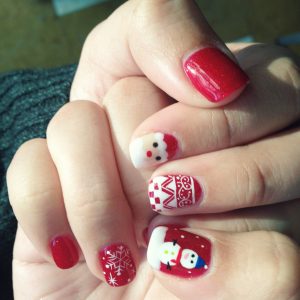 Arte de uñas adornado con decoraciones navideñas festivas. | Crédito: Getty images.