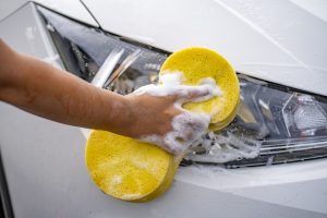 Limpiando luces de un carro. | Crédito: Getty images.